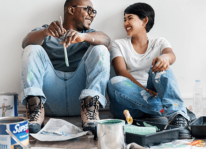 Couple sitting together with paint brushes in their hands