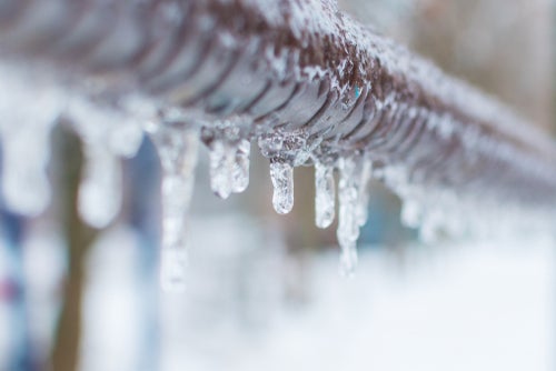 A frozen water pipe with icicles hanging off it