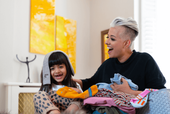 Mother and daughter sorting pile of laundry