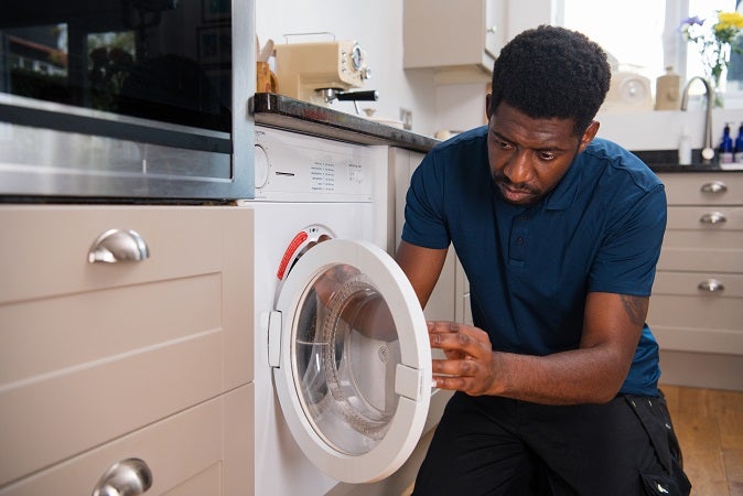 Children smiling while taking out laundry from tumble dryer