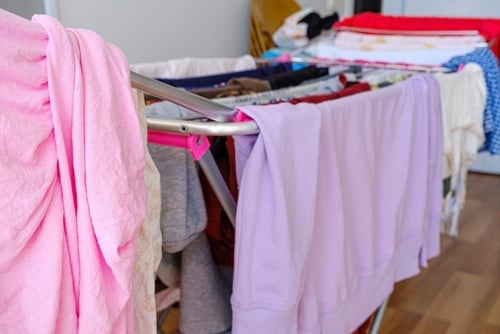 Clean laundry hanging on a clothes horse inside