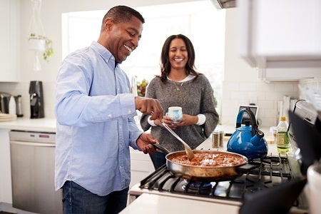 Couple cooking dinner on the hob