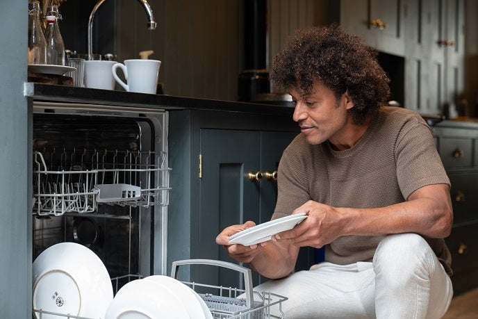 Father loading plates into the dishwasher