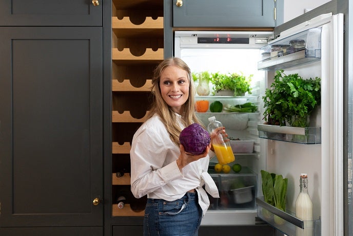 Mother putting the food shopping into the fridge